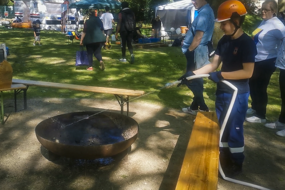 Die Jugendfeuerwehr löscht das Lagerfeuer der Pfadfinder*innen am Ende des Tages. (Foto: Alix von Schirp / BootMedia Media Production) 20230603_AlixVSchirp_Jugendring-Sommerfest-2023-21